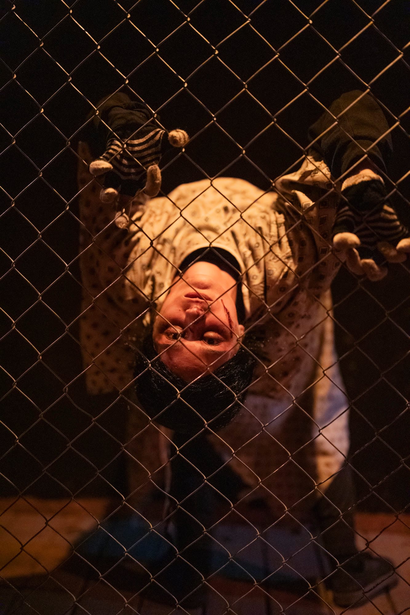 A burlap-faced character hanging on a fence